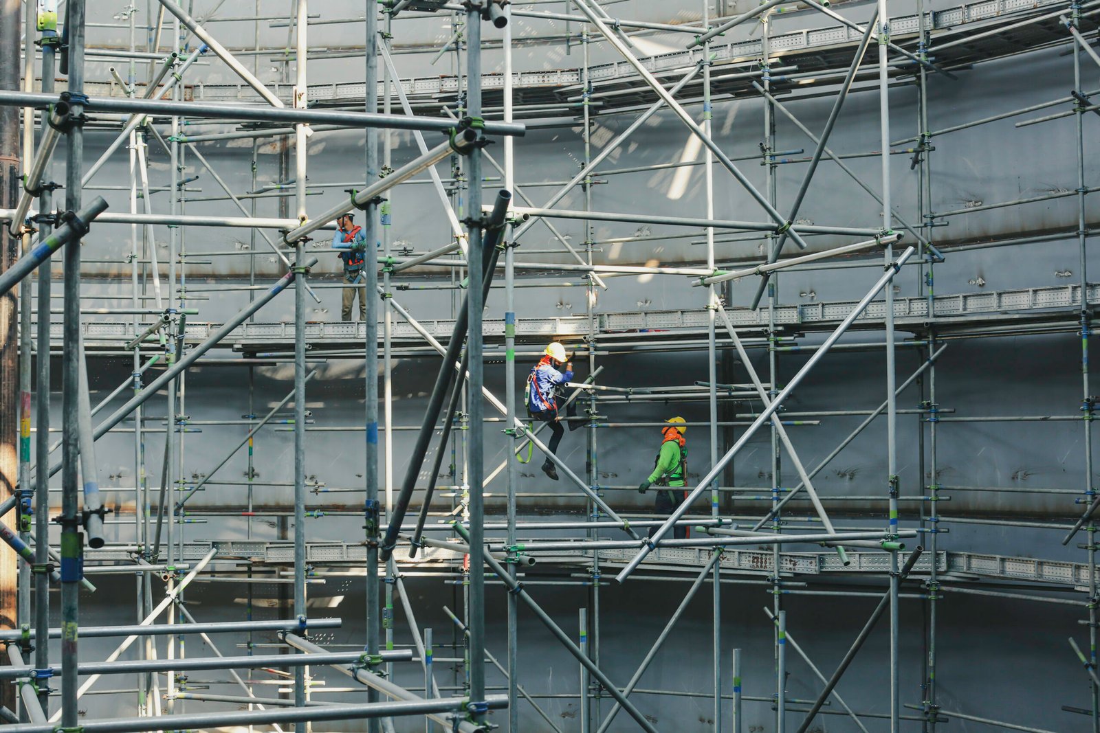 Construction workers tank oil installing scaffolding